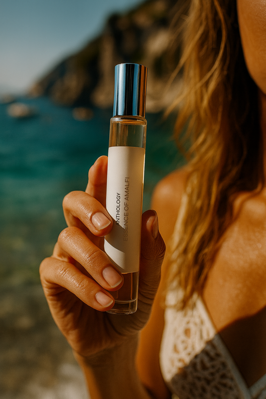 Person holding a perfume bottle by the beach